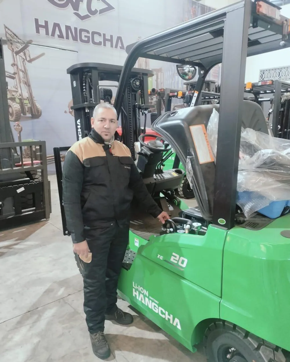 Technicien HER devant un chariot élévateur électrique Hangcha XE